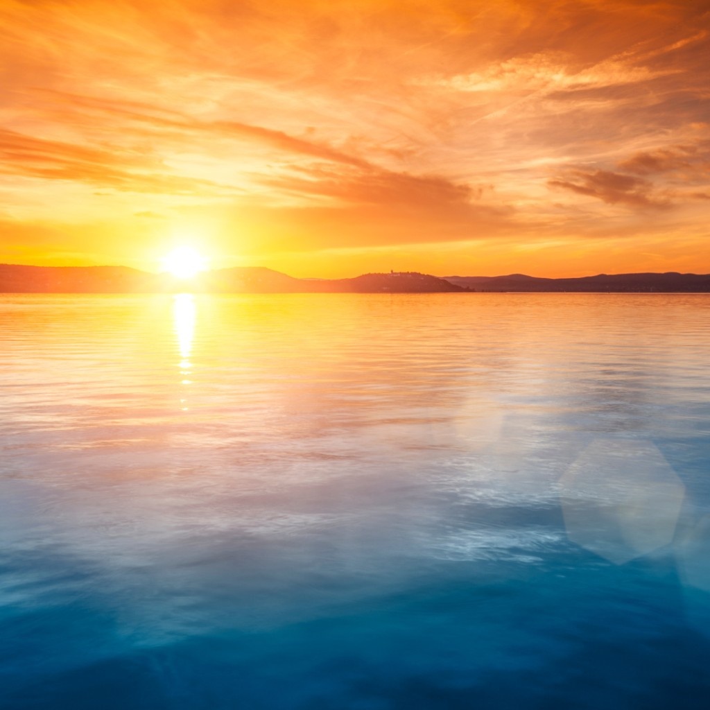 Sonnenuntergang über ruhigem Wasser